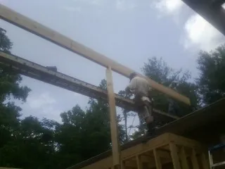 Carpenter setting a ridge beam over a new addition frame — Ice Dam Removal by Roofing Brothers in Vickery