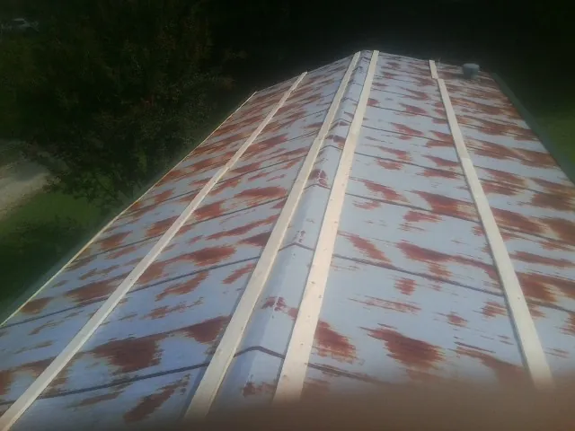 Rusted metal roof panels with new wood purlins before replacement — Storm Damage Roof Repair in Vickery by Roofing Brothers
