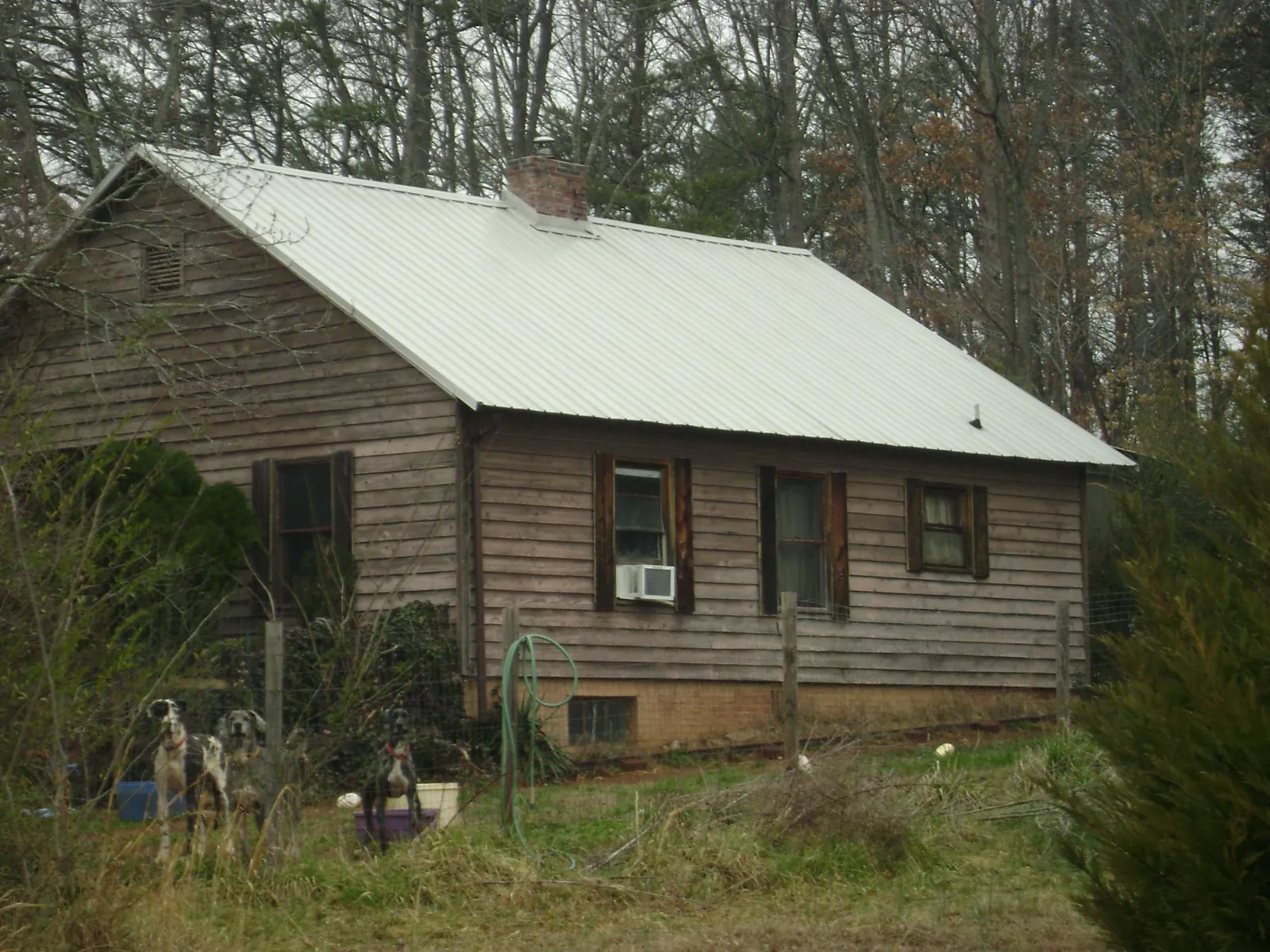 White metal roof on an old wood sided farmhouse, from a Metal Roof Installation job in Vickery